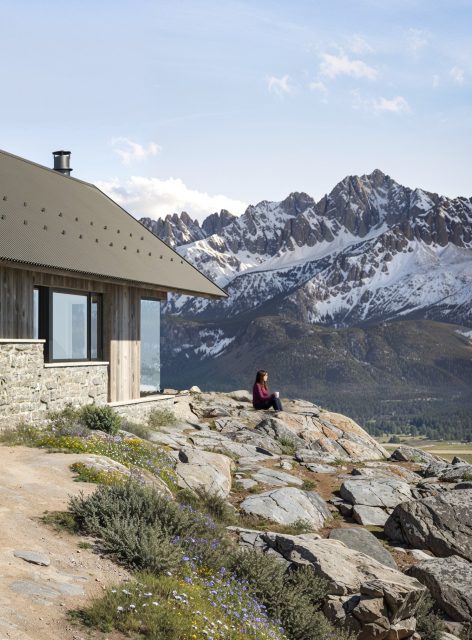 Architectural render of woman enjoying drink and looking at Sawtooth mountains from Idaho's cabin cliff.